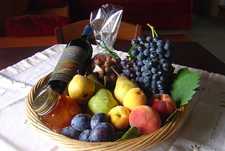 Welcome basket for our guests with local products of the Cascina dei Giacinti: our barbera wine, our jam and fruits of the current season from our orchard